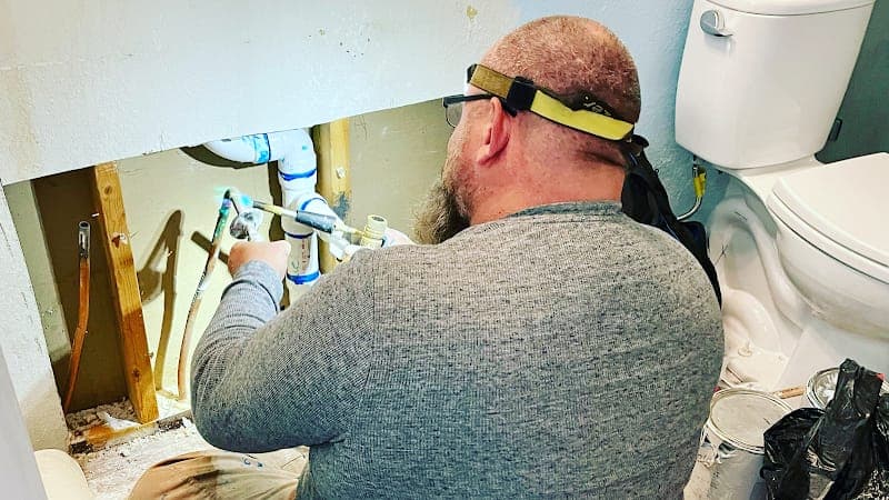 Licensed plumber performing sewer line inspection